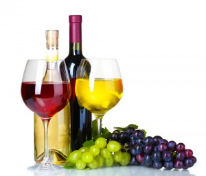 Ripe grapes, wine glasses and bottles of wine isolated on white